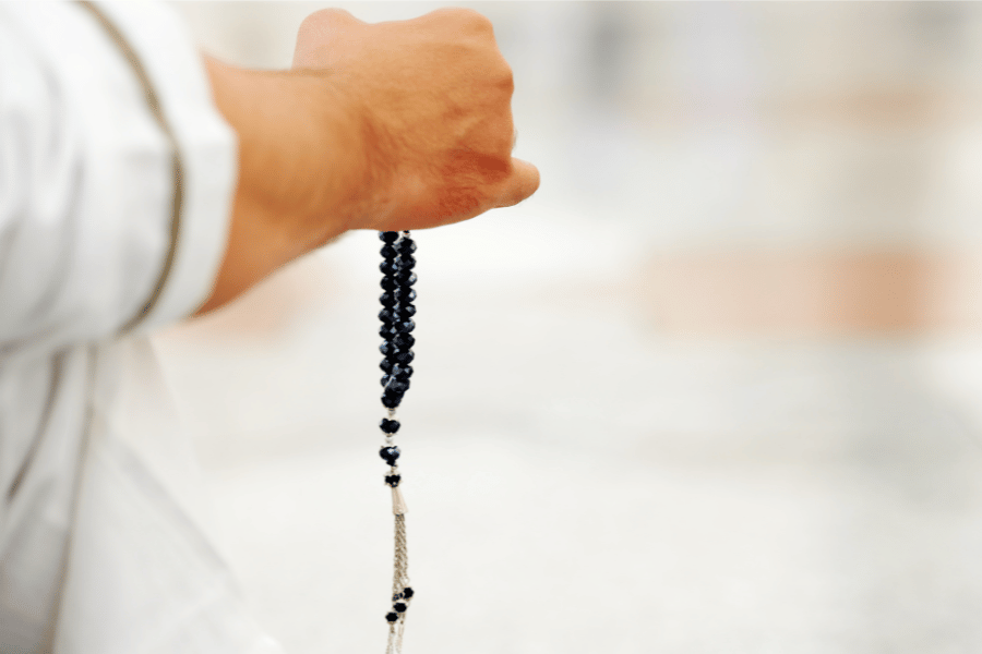 Man praying with rosary beads in hand